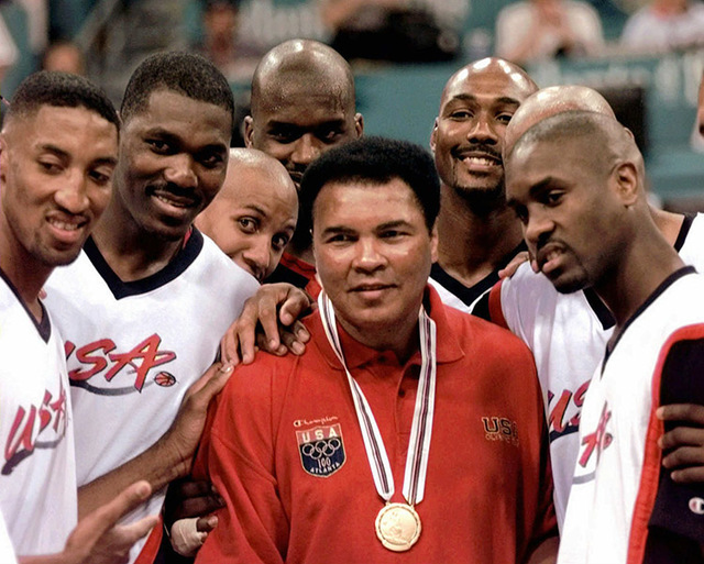 Muhammad Ali poses with Dream Team members  from left: Scottie Pippen, Hakeem Olajuwon, Reggie Miller, Shaquille O'Neal, Karl Malone and Gary Payton after receiving the gold medal, which replaces  ...