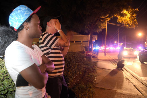 Jermaine Towns, left, and Brandon Shuford wait down the street from a shooting at Pulse nightclub in Orlando, Fla., Sunday, June 12, 2016, where 49 people were shot to death. Towns said his brothe ...