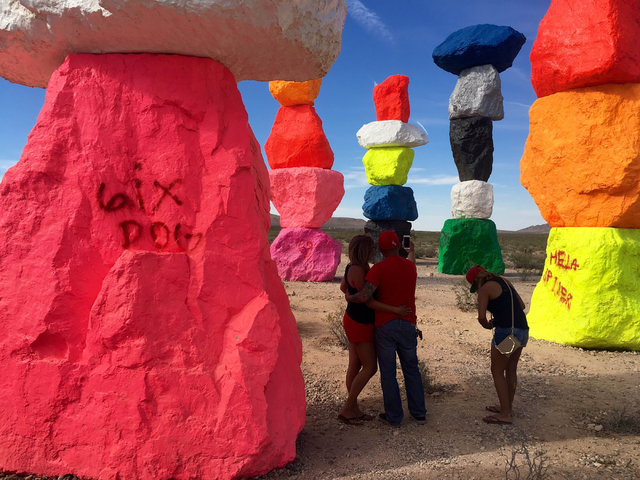 People take pictures at the Seven Magic Mountains art project off Interstate 15 on Sunday, June 5, 2016. Vandals defaced several of the limestone boulders that make up the project created by artis ...