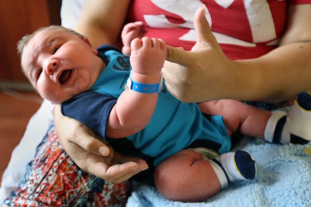 Moses William Hilton grabs his mother's finger at Hutchinson Regional Medical Center, in Hutchinson, Kan. Moses weighed over 14 pounds when he was born on June 2, at the hospital. (Sandra J. Milbu ...