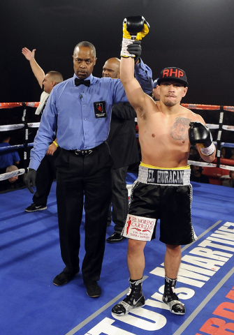 Referee Kenny Bales hoists the hand of Jesus Gutierrez after Guitierrez knocked out Pablo Becerra in the first round of their lightweight bout at the Tropicana Hotel Pavilion in Las Vegas Saturday ...