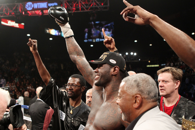 Deontay Wilder, center, reacts after being announced the new WBC heavyweight title champion after his bout against Bermane Stiverne at the MGM Grand Garden Arena in Las Vegas Saturday, Jan. 17, 20 ...