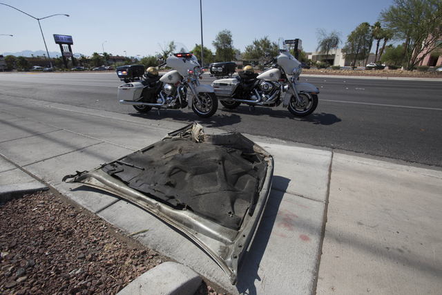 A wrecked hood of a car is seen on the sidewalk at the scene of a crash near the intersection of West Sahara Avenue and South Decatur Boulevard in Las Vegas on Saturday, June 25, 2016. Richard Bri ...