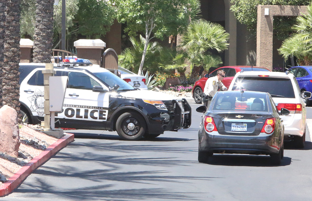 A Las Vegas police officer talks to residents outside a two-story apartment complex at 8000 Spring Mountain Road, near Buffalo Drive where one person died and two adults were displaced after a fir ...