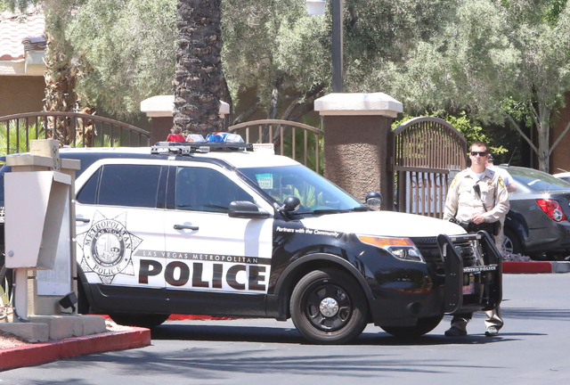 A Las Vegas police officer stands guard outside a two-story apartment complex at 8000 Spring Mountain Road, near Buffalo Drive where one person died and two adults were displaced after a fire on M ...