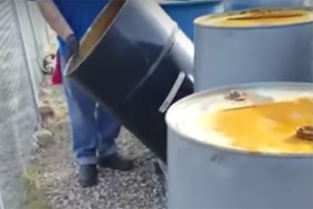 Video footage shows workers draining barrels of liquid in the Nevada desert. (Screengrab/Joseph Baylon/YouTube)