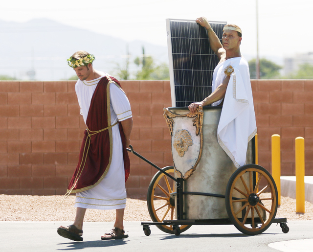 Joshua Self, left, dressed as a warrior pulls a chariot carrying Chris Justis, dressed as Apollo, and a solar panel during a news conference at Cox Las Vegas on Monday, June 20, 2016, in Las Vegas ...