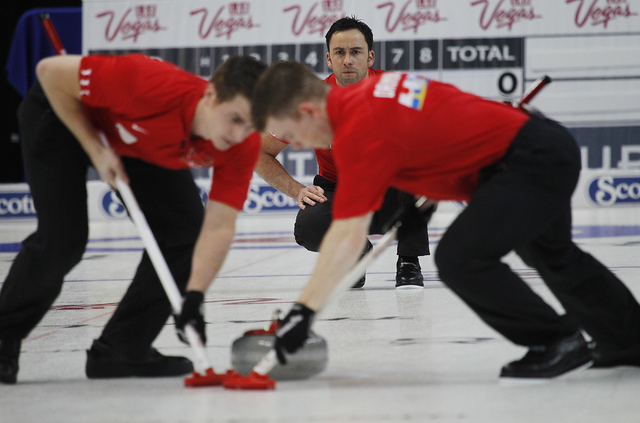 Team World's David Murdoch, in back, delivers a rock as teammates Greg Drummond, right, and Scott Andrews sweep the ice during the 2014 World Financial Group Continental Cup of Curling at the Orle ...