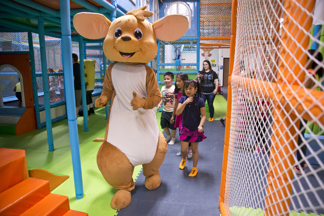 A costumed mascot walks with children inside Kangamoo Indoor Playground May 27, 2016. The playground is one of many in the valley that offer a supervised, climate-controlled space for parents to b ...