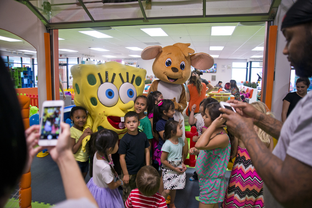 Children pose with costumed visitors inside Kangamoo Indoor Playground located near McCarran Airport on Friday, May 27, 2016. The playground is one of many in the valley that offer a supervised, c ...