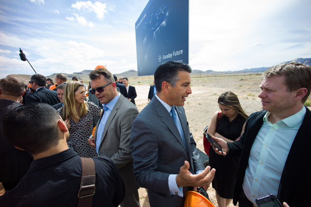 Gov. Brian Sandoval, center right, and Faraday Future Vice President of Manufacturing Dag Reckhorn, center left, speak with reporters following the groundbreaking for Faraday Future's planned 900- ...