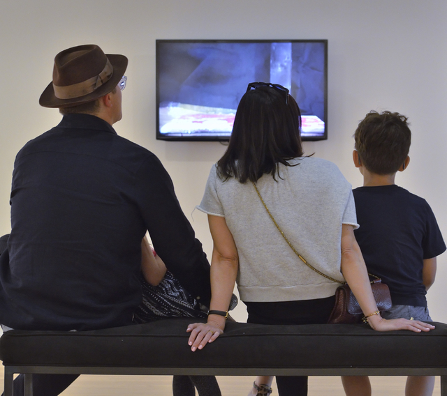 Shawn Giordano, left, Susan Huff, center, and Otto Giordano watch a video by artist Ash Ferlito at the “Five” exhibit in UNLV's Barrick Museum. Bill Hughes/Las Vegas Review-Journal