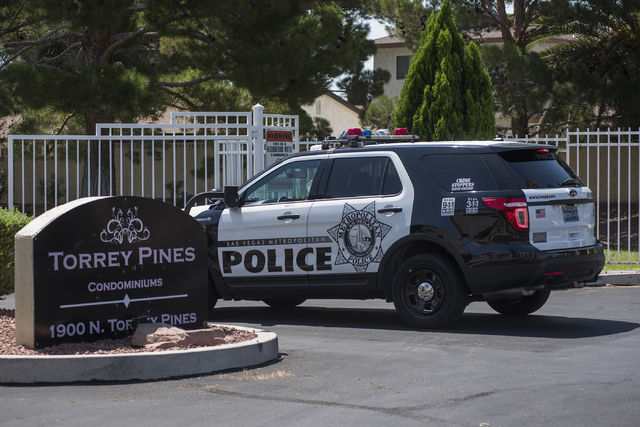 A Las Vegas police officer is seen at Torrey Pines Condominiums in Las Vegas on Thursday, June 30, 2016. Three children were found shot dead in a unit Wednesday night. Police said a man killed his ...