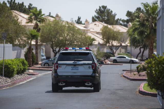 A Las Vegas police officer is seen at Torrey Pines Condominiums in Las Vegas on Thursday, June 30, 2016. Three children were found shot dead in a unit Wednesday night. Police said a man killed his ...