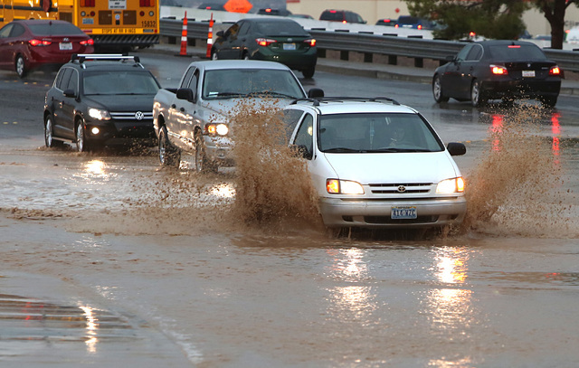 Motorists navigate through a flooded street near Russell Road and Whitney Ranch in Henderson as late afternoon storms move through Las Vegas Valley on Thursday, June 30, 2016. (Bizuayehu Tesfaye/L ...