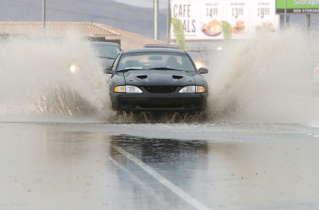 Motorists navigate through a flooded street near Russell Road and Whitney Ranch in Henderson as late afternoon storms move through Las Vegas Valley on Thursday, June 30, 2016. (Bizuayehu Tesfaye/L ...