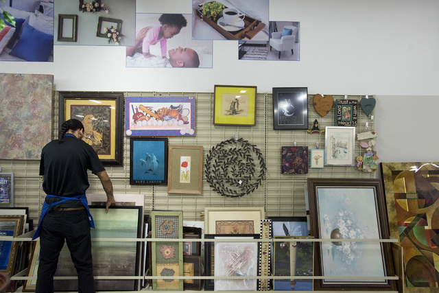 Employee Christian Lopez puts art out for sale at the Goodwill Retail and Donation Center at Boulevard Mall in Las Vegas on May 31, 2016. Bridget Bennett/Las Vegas Review-Journal Follow @bridgetkb ...