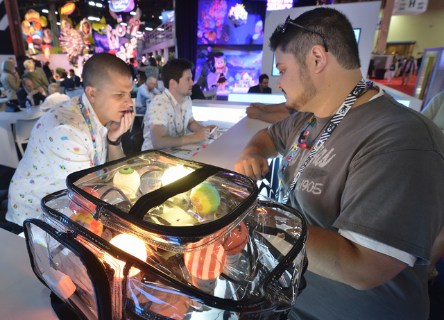 Mark McCoy, licensing manager for HueVee, a company making custom-branded LED light bulbs, right, talks with Mark Putnam, Cartoon Network marketing manager, during the Licensing Expo at the Mandal ...