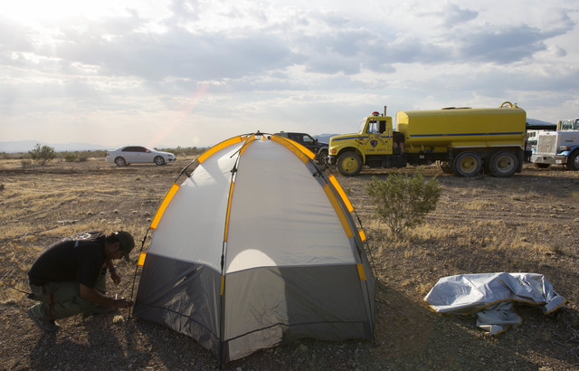 Fernando Reyes, with the Nevada Division of Forestry, assembles his tent at a base camp for fire crews fighting the Lovell wildfire near state Route 160 and Lovell Canyon Road on Monday, June 27,  ...