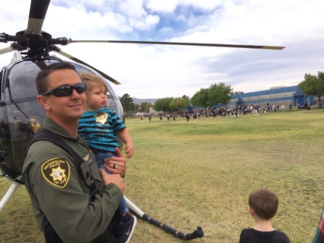 Metropolitan Police Department Officer Spencer Basner, a Metro helicopter pilot for 10 years, holds his son, Burke, 19 months, May 20, 2016, at Marc A. Kahre Elementary School, 7887 W. Gowan Road, ...