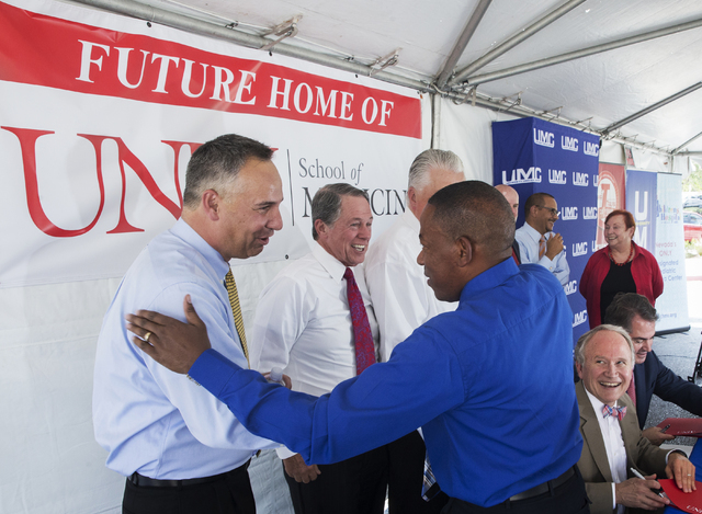 University Medical Center CEO Mason Van Houweling, left, shakes hands with Clark County Commissioner Lawrence Weekly during an event to commemorate the commission's decision to give UNLV a 9-acre  ...
