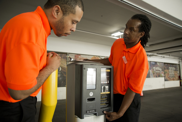 Matthew Smith, right, teaches Richard Jackson about the parking entry kiosk on the first day of paid parking at the Monte Carlo hotel-casino parking garage on the Las Vegas Strip on Monday, June 6 ...