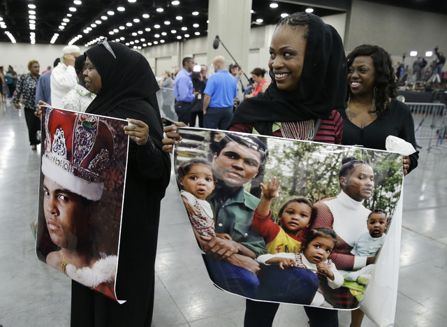 Mourners hold photos of Muhammad Ali after his Jenazah, a traditional Islamic Muslim service, in Freedom Hall, Thursday, June 9, 2016, in Louisville, Ky. (Darron Cummings/AP)