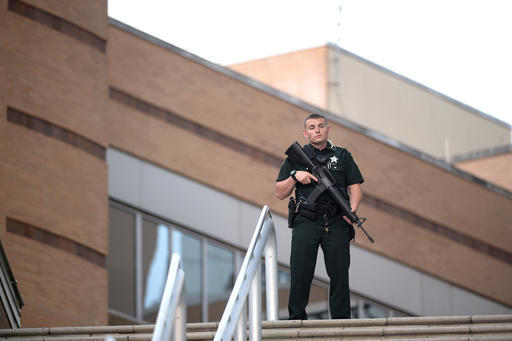 A police officer stands guard outside the Orlando Regional Medical Center hospital after a fatal shooting at a nearby Pulse Orlando nightclub in Orlando, Fla., Sunday, June 12, 2016. (Phelan M. Eb ...