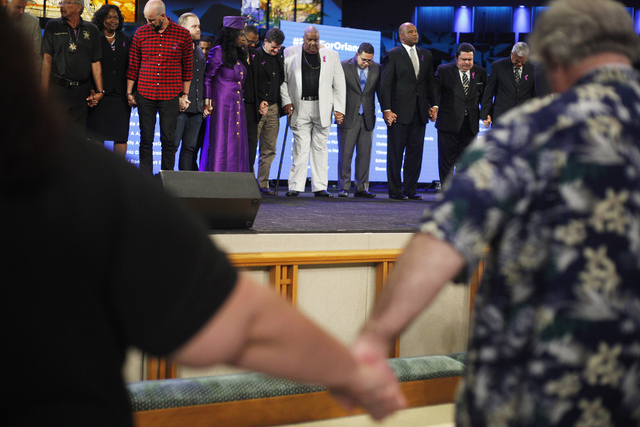 Community and religious leaders gather on stage to pray at a service to honor victims of the Orlando nightclub shooting at the First Baptist Orlando Church in Orlando, Florida on Tuesday, June 14, ...