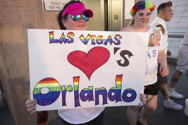 A marcher raises a placard as members of the community gather on the Las Vegas Strip to show their solidarity for the victims of the Pulse nightclub shooting in Orlando, Fla., in Las Vegas on Mond ...