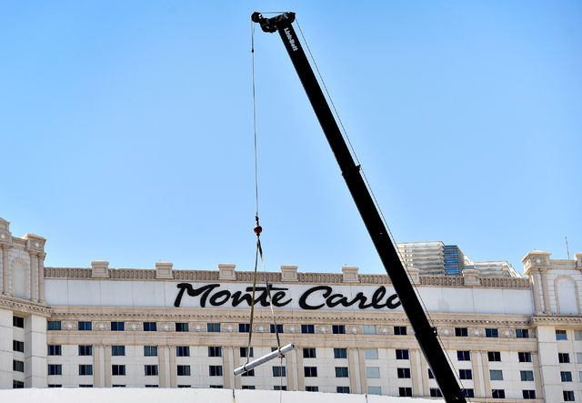 A construction crane lowers a piece of pipe near the Monte Carlo hotel-casino Friday, June 3, 2016, in Las Vegas. MGM Resorts International announced the Monte Carlo will be transformed into two h ...