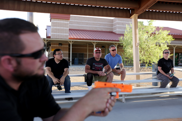 A.J. Clark, Adapt instructor, far left, leads a lesson in shooting positions as Eric Tsou, Joe Fishinghawk, Lynn Norman, and Elspeth Thompson listen on Friday, June 24, 2016 at the Clark County Sh ...