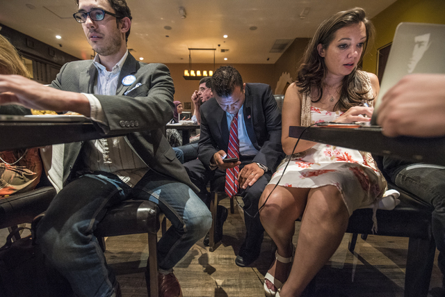 Steven Conger Jr., assistant campaign manager, from left, Democratic Congressional District 3 candidate Jesse Sbaih, and campaign manager Angie Morelli look at election results during a campaign e ...