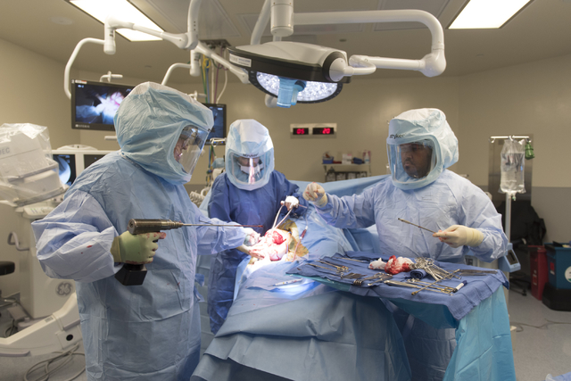 Dr. Ronald Hillock, left, Deanna Rechtzigel, advanced practice registered nurse, center, and Jay French, certified scrub technician, perform osseointegration surgery at Centennial Hills Hospital i ...
