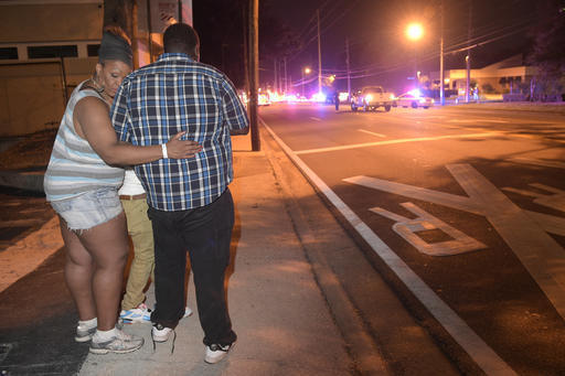 Bystanders wait down the street from a multiple shooting at the Pulse nightclub in Orlando, Fla., Sunday, June 12, 2016. A gunman opened fire at a nightclub in central Florida, and multiple people ...
