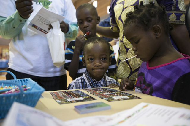 Jackson Dusabe, clockwise from left, his son Joel, 9, wife Hariet Rwagize, daughter Gloria, 5, and son Victor, 3, refugees from the Democratic Republic of the Congo, attend a Catholic Charities Wo ...
