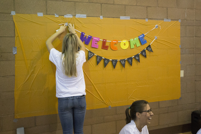 Volunteer Landyn Dyer puts up a banner during a Catholic Charities World Refugee Day fair at Our Lady of Las Vegas Roman Catholic Church on Friday, June 17, 2016, in Las Vegas. Erik Verduzco/Las V ...