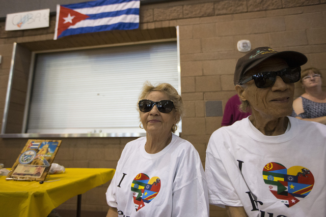 Volunteers Barbara Alburquerque, left, and her husband Jorge, who came to the United States as refugees in 1970 from Cuba, share their story during a Catholic Charities World Refugee Day fair at O ...