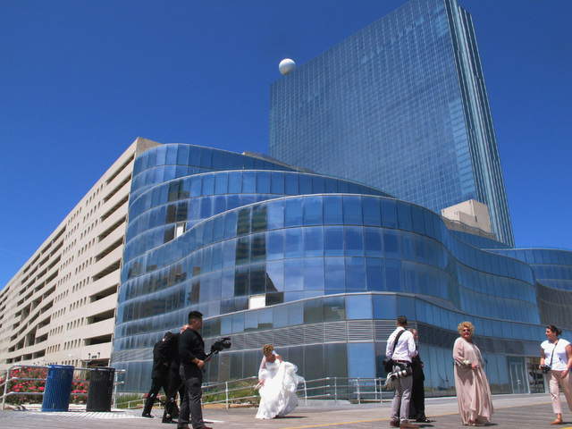 A wedding party searches for spots for a photo near the former Revel casino in Atlantic City, N.J., Friday, June 10, 2016. Revel and its next-door neighbor the Showboat both closed in 2014, and ar ...