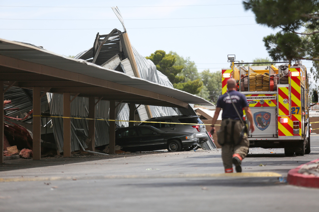 Clark County Fire Department workers tend to a roof collapse near the intersection of East Sahara Avenue and Boulder Highway on Thursday, June 9, 2016 in Las Vegas. The collapse damaged cars parke ...