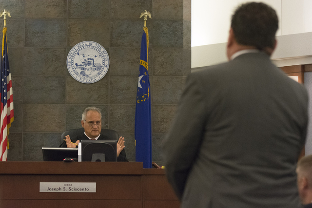 Louis C. Schneider, attorney for Desert Pines High School teacher Jonathan Scheaffer, right, speaks with Judge Joseph S. Sciscento, Scheaffer's court appearance at the Regional Justice Center in L ...