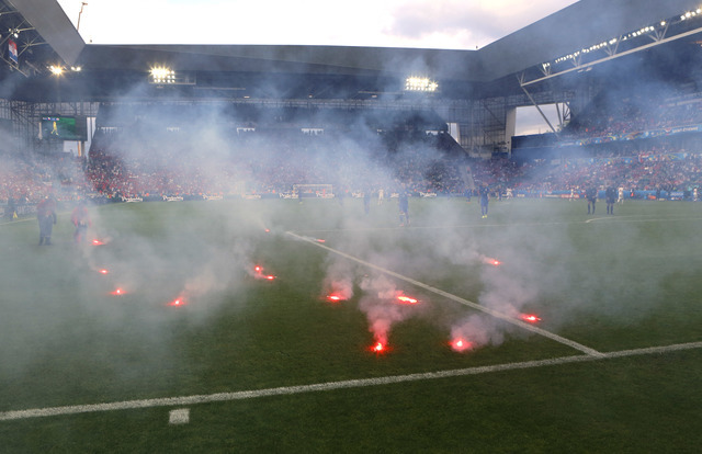 Flares are thrown onto the pitch during the Euro 2016 Group D soccer match between the Czech Republic and Croatia at the Geoffroy Guichard stadium in Saint-Etienne, France, Friday, June 17, 2016.  ...