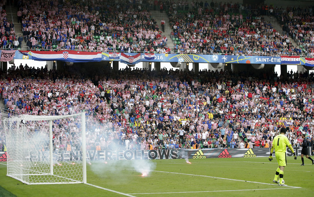 Czech Republic goalkeeper Petr Cech, right, looks at burning flares thrown on to the pitch from the stands during the Euro 2016 Group D soccer match between the Czech Republic and Croatia at the G ...