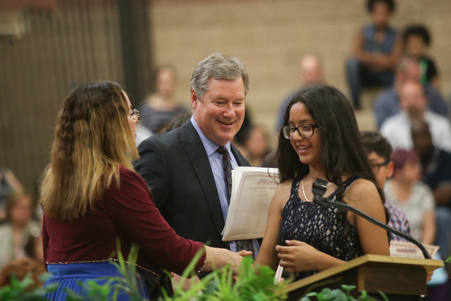 Principal Lisa Medina, left, and Assistant Principal Stephen Wood, center, congratulate an eighth grade student at a promotion ceremony at Monaco Middle School in Las Vegas on Thursday, May 26, 20 ...