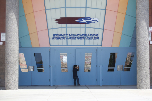 A child opens the door to Monaco Middle School, where a promotion ceremony is being held for eighth grade students moving on to high school, in Las Vegas on Thursday, May 26, 2016. (Brett Le Blanc ...