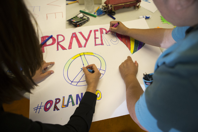 Attendees make signs before the candle light vigil to honor victims of the Orlando mass shooting at the The Gay and Lesbian Community Center of Southern Nevada on Sunday, June 12, 2016, in Las Veg ...