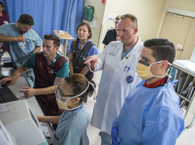 Dr. Douglas Fraser, second from right, chief of UMC's trauma surgery section and an assistant professor with the University of Nevada Medical School of Medicine in UMC Trauma Center views X-rays w ...
