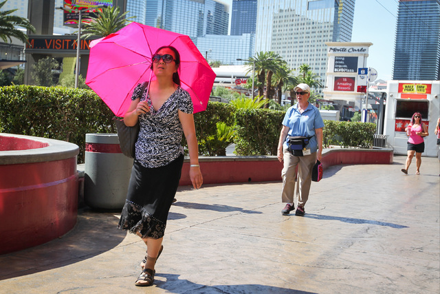 A woman walking along the Strip in triple-digit heat shields herself from the sun with an umbrella in Las Vegas on Monday, June 20, 2016. Brett Le Blanc/Las Vegas Review-Journal Follow @bleblancphoto