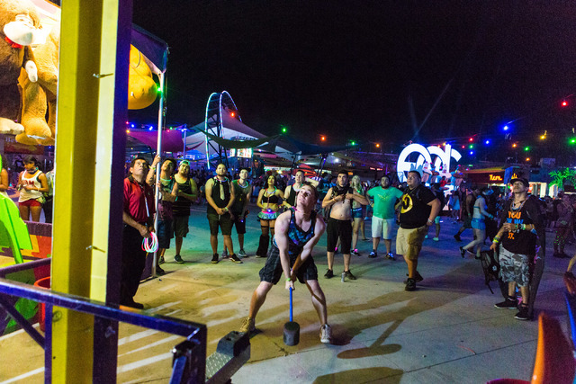 David Husky from Lake Forest, CA hits the bell playing the carnival game Strong Man during the second night of Electric Daisy Carnival at Las Vegas Motor Speedway early Sunday morning, June 19, 20 ...
