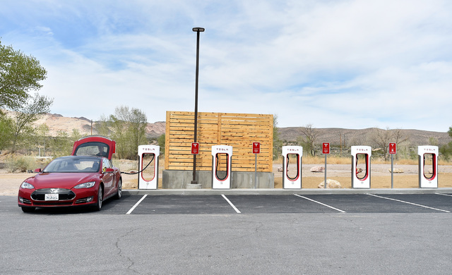 A Tesla electric car is seen charging before the dedication first electric car charging station along U.S. Highway 95 Tuesday, March 1, 2016, in Beatty. The station is the fist of many planned cha ...